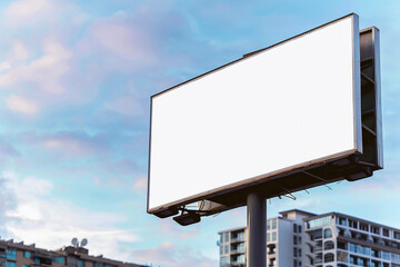 Fototapeta premium Blank billboard mockup with white screen against clouds and blue sky background. Copy space banner for advertisement. Business Concept.