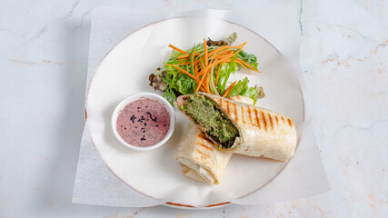 Sliced durum kebab on plate with vegetables