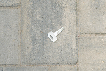 the key lies on the paving slabs. lost and found. top view