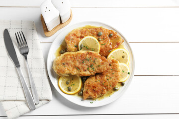 Delicious chicken piccata served on white wooden table, flat lay