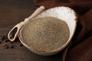 Ground pepper and peppercorns on wooden table, closeup