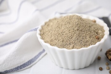 Ground pepper on white tiled table, closeup
