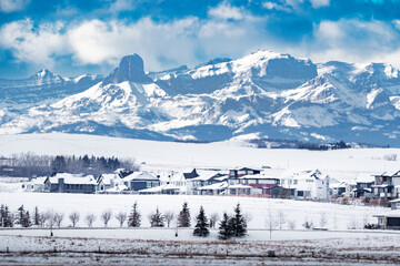 New community of Harmony overlooking farm fields and the Canadian Rocky Mountains West of the City of Calgary during winter.