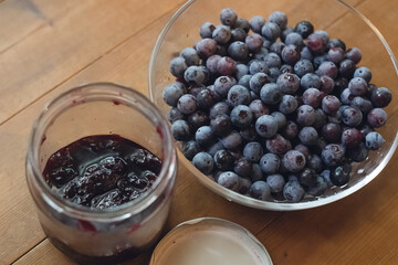 家庭菜園、庭の朝採れ、ガラスのボウルに入ったブルーベリーの山と手作りブルーベリージャム