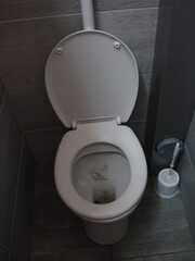 A toilet in a summer camping toilet with gray walls
