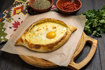Traditional georgian khachapuri with egg yolk on wooden background