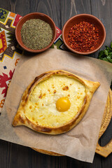 Traditional georgian khachapuri with egg yolk on wooden background