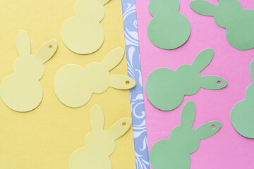 yellow and green tags in the shape of stylized rabbits on yellow and pink paper with a decorative stripe