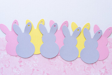 mauve, pink, and yellow bunny tags on blank paper and pink paper with texture