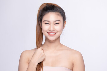 Radiant young Asian woman with a high ponytail and glowing skin smiling at the camera