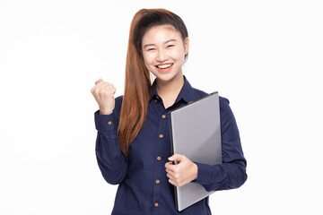 Joyful Asian businesswoman with a high ponytail, holding a laptop and celebrating success with a fist pump