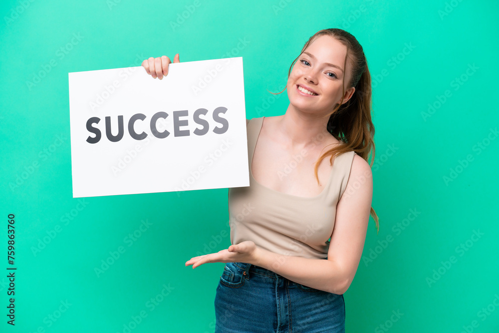 Canvas Prints Young caucasian woman isolated on green background holding a placard with text SUCCESS with happy expression