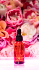 A cosmetic jar stands on a floral background with neon lighting. Liquid serum for face and body. The concept of natural youth cosmetics and perfumes. Front view