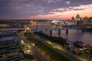 Downtown district of Cincinnati city in Ohio, USA at night with driving cars traffic on bridge and...