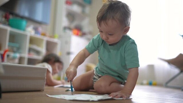 children sit on the floor and draw on paper. happy family child dream concept. baby boy and girl sitting indoors on the floor and drawing with pencils on paper lifestyle. children draw a