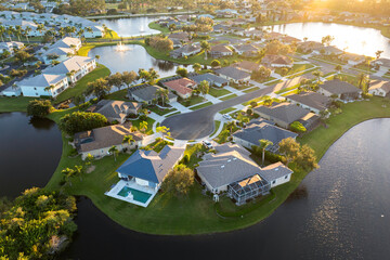 Low-density private homes at sunset. Rural street cul-de-sac dead end in residential suburbs with upscale suburban houses outside of Sarasota, Florida - obrazy, fototapety, plakaty
