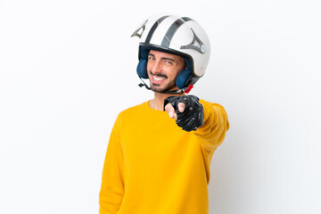 Young caucasian man with a motorcycle helmet isolated on white background pointing front with happy...