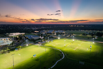 Sportsmen training in soccer game on illuminated football stadium in public sports park in North...