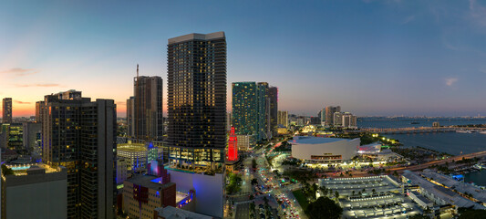 View from above of brightly illuminated skyscraper buildings in downtown district of Miami Brickell in Florida, USA at night. American megapolis with business financial district