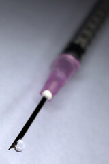Naklejka premium Syringe and needle with drop of clear liquid