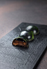 Box of assorted chocolates on dark background. Top view.