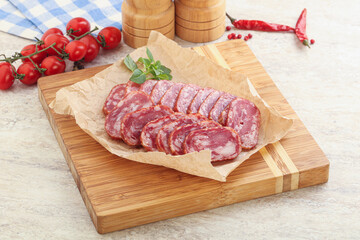 Sliced salami sausages over board