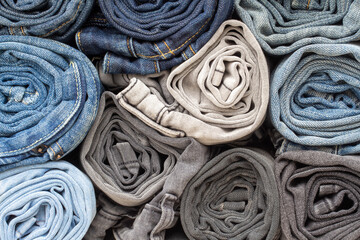 stack of jeans of different colors, close up of jeans background