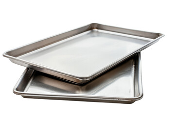 Stacked silver baking trays with a shiny finish and visible usage marks isolated on a black background