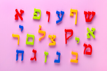  Fridge magnet Hebrew alphabet spelling letters over pink background.