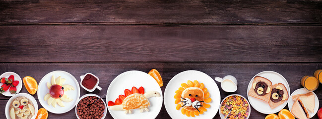 Fun child theme breakfast bottom border with an assortment of animal themed foods. Top view on a...