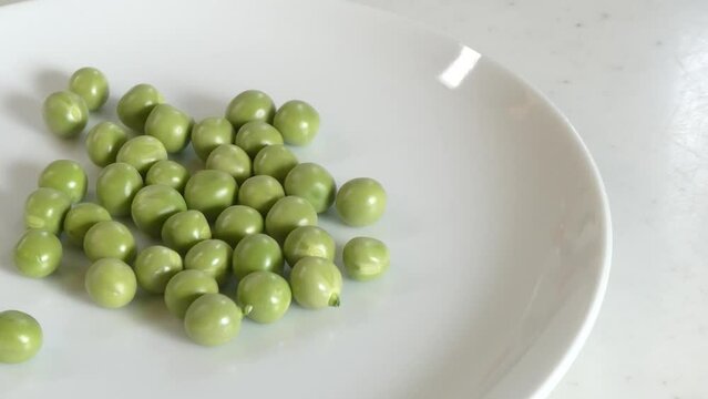こぼさずにグリーンピースを断続的に皿に注ぐ