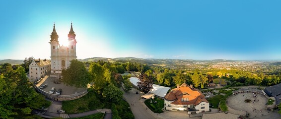 Panorama-Luftaufnahme von Linz und dem Pöstlingberg mit untergehender Sonne dahinter
