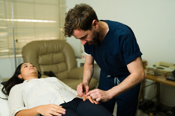 Hispanic therapist doing acupuncture therapy