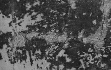 A weathered concrete wall with cracks and peeling paint, showing signs of age and decay.