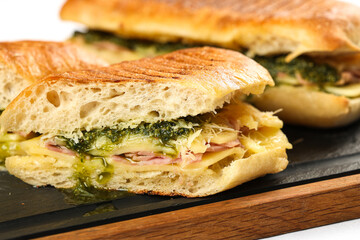 Prosciutto and pastrami sandwich. Close up photo with a tasty homemade sandwich with prosciutto cheese basil sauce and fresh ciabatta bread.