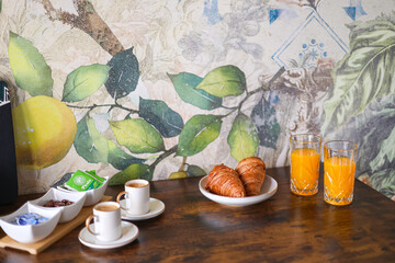 Cozy breakfast in the morning. Close up photo with orange juice, French croissants, coffee and milk...