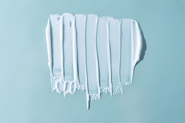 Stroke of white cream on a blue background.