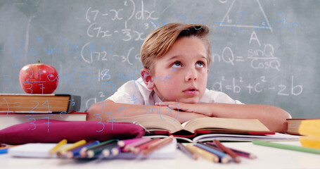 Image of math formulas over thoughtful caucasian boy learning at school