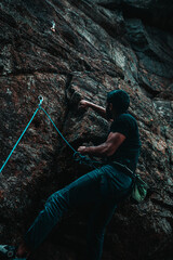 Obraz premium Man climbing a rocky mountain wall