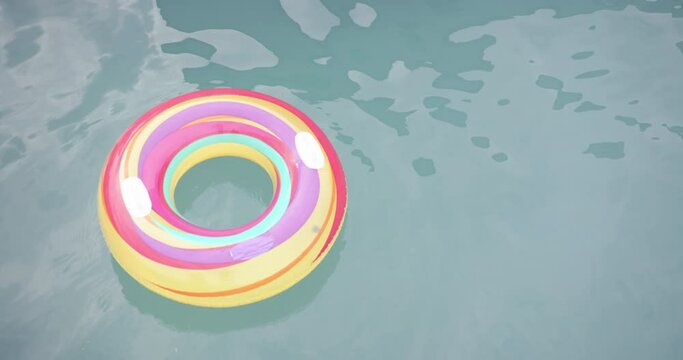 A colorful inflatable ring floats on a pool's surface