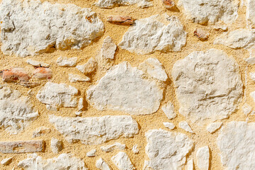 Background. An ancient wall made of archaically processed stone. The wall of the ancient building is made of stones.