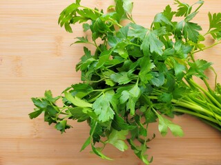 Bunch of lovage leaves on wooden background.