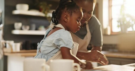 African, mom and child helping in kitchen and learning baking in home together with flour in morning. Black mother, cooking and teaching kid to clean table in preparation for bread or food in house