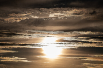 Fototapeta na wymiar Untergehende Sonne zwischen den Wolken