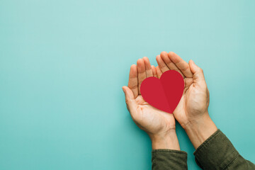 Valentines day, love, donate and blood donation. Woman holding red paper heart in her hand