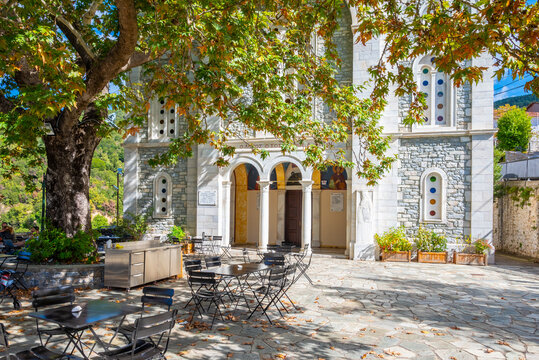 The central square with the century-old plane trees and the three-story church dedicated to the Dormition of the Virgin, Agios Charalambos and Agia Paraskevi in Vamvakou village, Peloponnese, Greece
