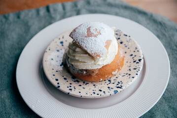 Typical Swedish semla with sweet cream on te blue textile