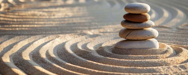 Zelfklevend Fotobehang Zen-like stones stacked on sand with symmetrical ripples around them, in a peaceful setting. © Netsai