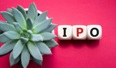 IPO- Initial Public Offering symbol. Concept word IPO on wooden cubes. Beautiful red background...