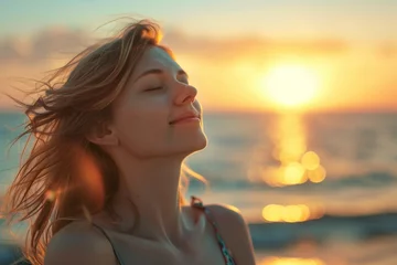 Gordijnen a woman at beach is smiling, sunset © gilles